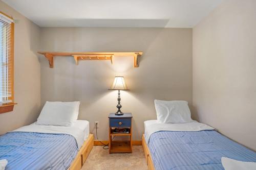 a bedroom with two beds and a lamp in it at Amazing Location Lakefront Waterside Deck in Chatham