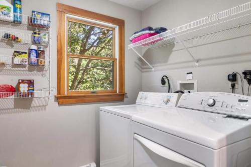 a washing machine in a white laundry room with a window at Amazing Location Lakefront Waterside Deck in Chatham