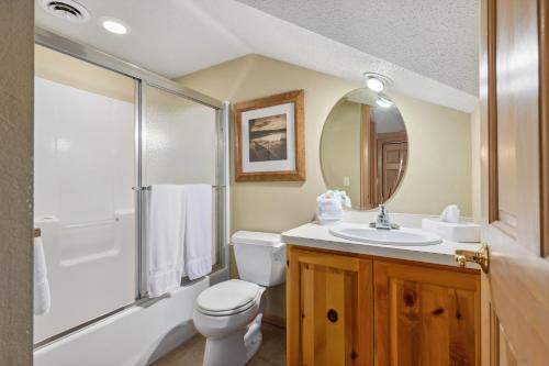 a bathroom with a toilet and a sink and a mirror at Causeway On Gull Resort in Lake Shore