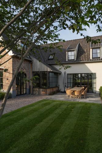a house with a table and chairs in a yard at Botanic Experience Holiday House in Oostkamp