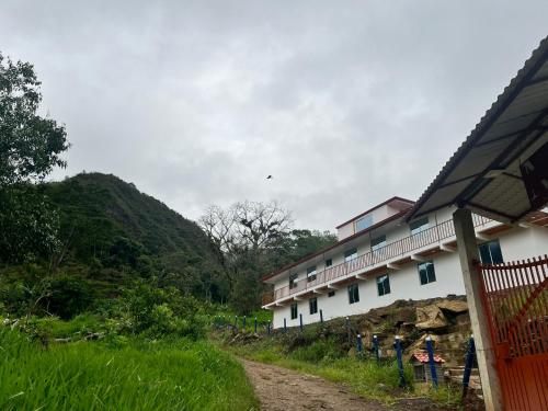 a building on a dirt road next to a mountain at Quinta Las Mendoza in Zetaquira