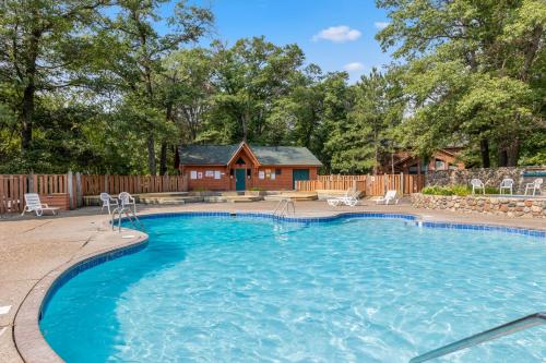 a swimming pool in front of a house at Causeway On Gull Resort in Lake Shore