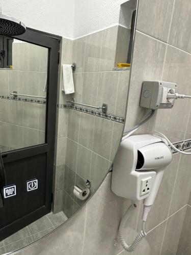 a bathroom with a soap dispenser and a mirror at Lola's Rooms in Gjirokastër