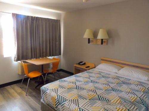 a hotel room with a bed and a desk and a window at Motel 6 Ontario, OR in Ontario
