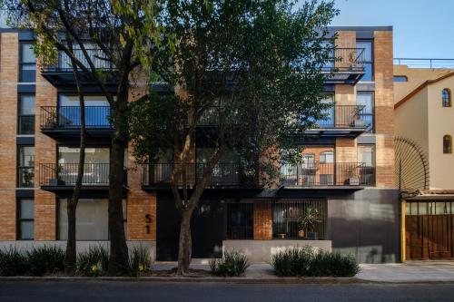 an apartment building with balconies and trees at Urban Reforma Mexico City by Lumina in Mexico City