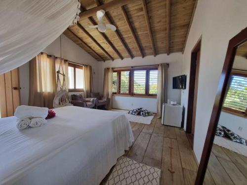 een slaapkamer met een groot wit bed in een kamer bij Casa Uzêda Trancoso in Porto Seguro