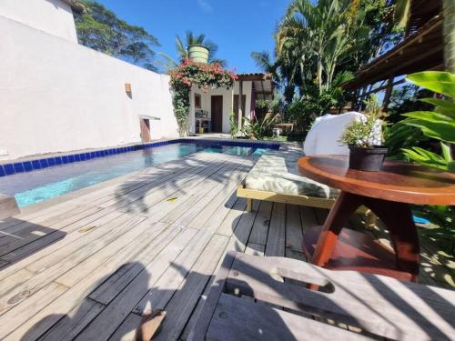 een terras met een tafel en een zwembad bij Casa Uzêda Trancoso in Porto Seguro