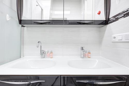 une cuisine blanche avec un évier et un comptoir dans l'établissement Place de la République - Suite Haussmannienne, à Paris