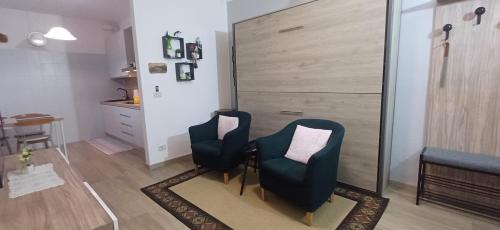 a living room with two chairs and a table at holiday home un piccolo angolo tra gnomi natura e relax in Tarvisio