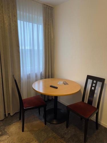 a room with a table and two chairs and a table at Hotel Hildesheimer Hof in Harsum
