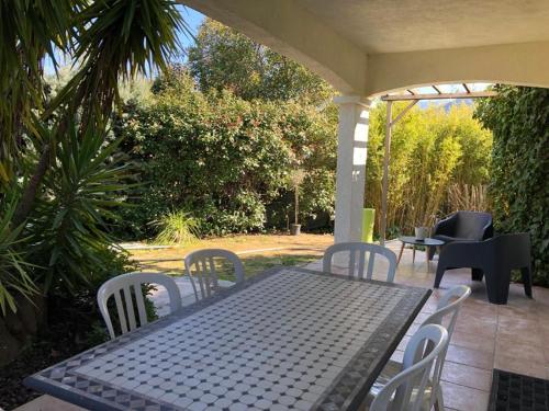 a black table and chairs on a patio at Porticcio- Duplex dans propriété privée in Cauro