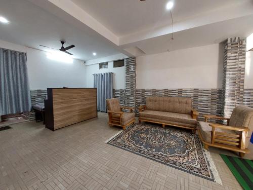 a living room with a couch and chairs and a piano at Manor Residency in Varanasi