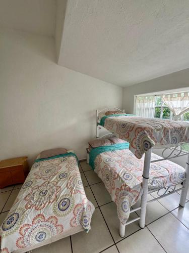 a bedroom with two bunk beds and a window at Villa Residencial Aéreo Albatros in Tequesquitengo