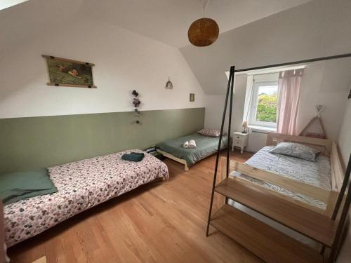 une chambre avec deux lits et un miroir dans l'établissement Maison Les 3 Soeurs - 8 à 10 personnes - plages à pied, à Brignogan-Plage