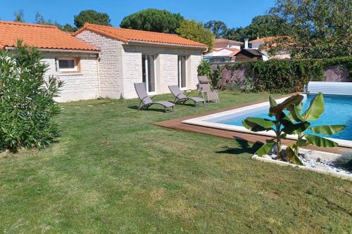 une cour avec deux chaises et une piscine dans l'établissement La loggia, à La Tremblade