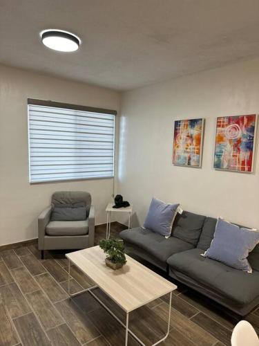 a living room with a couch and a table at Cómodo Departamento para 5 in Ciudad Juárez