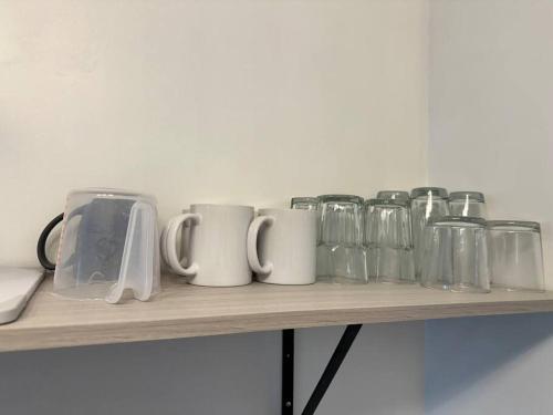 a shelf with several mugs and glasses on it at Cómodo Departamento para 5 in Ciudad Juárez