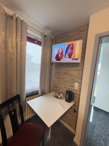 a room with a table and a tv on a wall at Hotel Hildesheimer Hof in Harsum