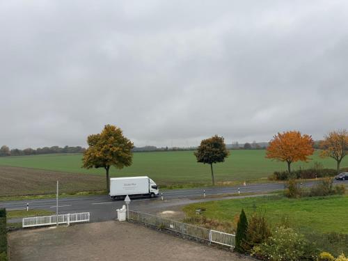 a white truck is driving down a road at Hotel Hildesheimer Hof in Harsum