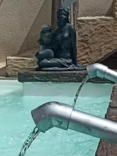 a water fountain with a statue in the background at Ala Pa cá in Miajadas
