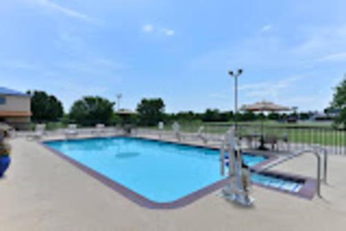 a large swimming pool with blue water at Baymont by Wyndham Ardmore I-35 in Ardmore