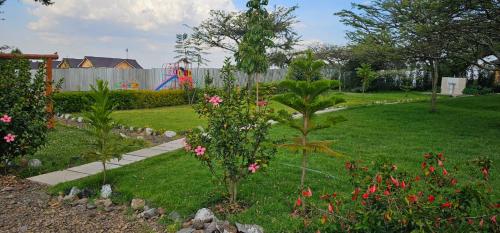 a garden with pink flowers in a yard at Juniper Park Resort in Nyahururu
