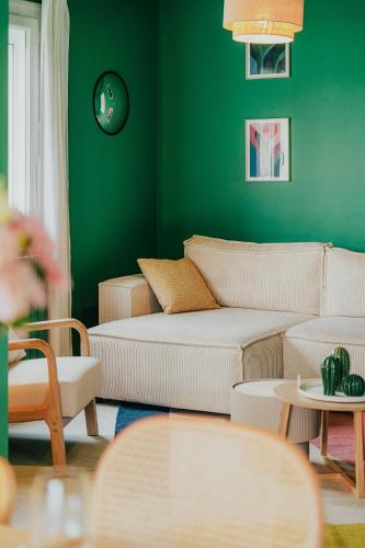 un salon avec des murs verts, des canapés et des tables dans l'établissement Maison 12 personnes, grand jardin, proche plages, animaux acceptés par Maison ELANORE, à Pleurtuit