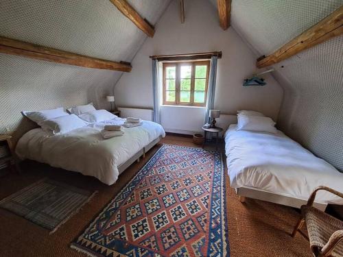 une chambre avec deux lits et une fenêtre dans l'établissement Havre de paix en pleine nature-Collection Idylliq, à Autheuil-Authouillet