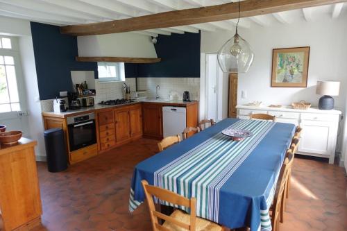 une cuisine avec une table avec un chiffon bleu et blanc dans l'établissement Havre de paix en pleine nature-Collection Idylliq, à Autheuil-Authouillet