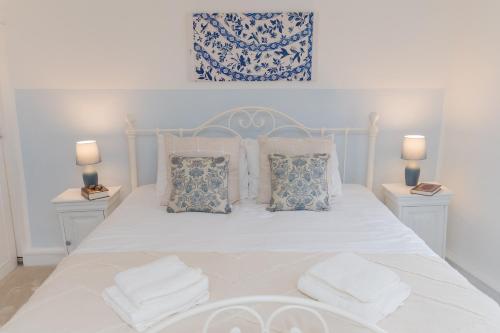 a bedroom with a white bed with pillows and two lamps at Honeystone Cottage Stanton near Broadway in Stanton