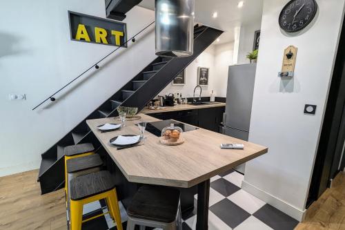 une cuisine avec une table en bois et un escalier dans l'établissement Grand duplex - Parking privé - Centre - Calme, à Toulouse