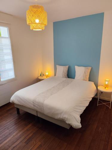 - une chambre avec un grand lit blanc et un mur bleu dans l'établissement Proche gare et centre-ville de Poitiers Emplacement idéal, à Poitiers