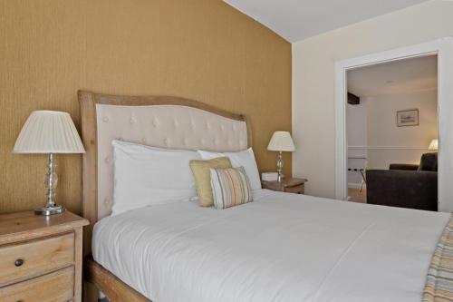 a bedroom with a large white bed and a chair at Sleeping Bear Hotels Dorchester in Dorchester