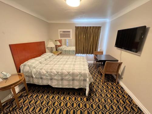 a hotel room with a bed and a flat screen tv at Griffith Park Motel, in Los Angeles Hollywood Area in Glendale