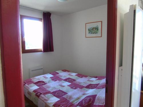 une chambre avec un lit avec une couette dessus dans l'établissement Résidence Cheval Blanc - 2 Pièces pour 6 Personnes MAE-8654, à Modane