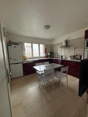 une cuisine avec une table, des chaises et un réfrigérateur dans l'établissement 2 spacious rooms for 4 people group, à Noisy-le-Sec