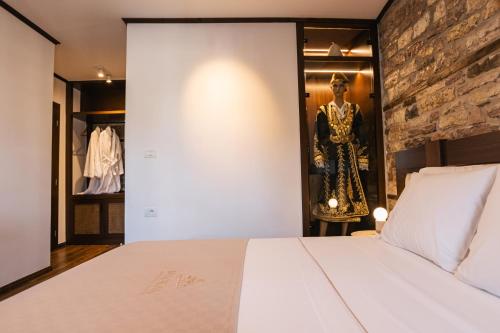 a bedroom with a white bed and a mannequin at N'SOKAK Boutique Hotel in Gjirokastër