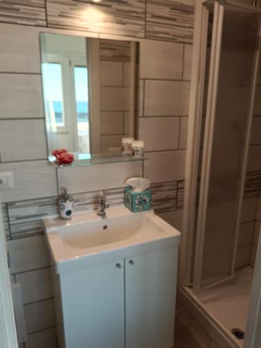 a bathroom with a sink and a mirror and a shower at Mare e Relax 1 Melody Sea Front 10' da FCO Airport in Fiumicino