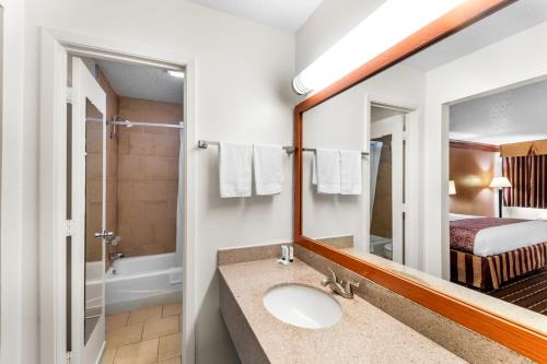 a bathroom with a sink and a mirror at Scottish Inns - Decatur in Decatur