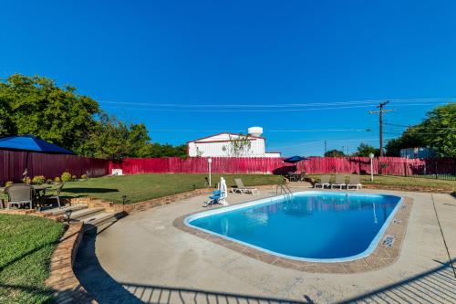 a swimming pool in a yard with a building in the background at Scottish Inns - Decatur in Decatur