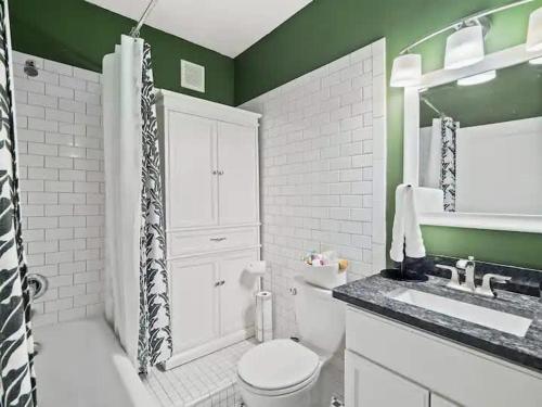 a green bathroom with a toilet and a sink at 19th Century 'Cleveland Double' - Walk To Beach in Cleveland