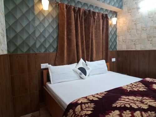 a bedroom with a bed with white pillows at Anand Niketan Homestay Shimla in Shimla
