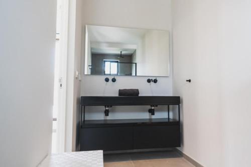 un baño con lavabo y espejo en Villa Blenchi, en Willemstad