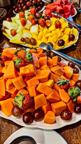 a table with two plates of cheese and fruit at Navega Hostel in Navegantes