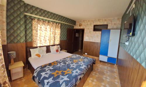a bedroom with a bed with a blue comforter at Anand Niketan Homestay Shimla in Shimla