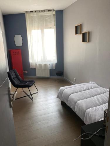 una camera da letto con un letto, una sedia e una finestra di Appartement 2 chambre roubaix a Roubaix