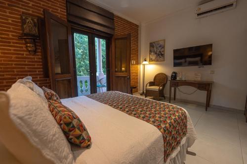 a bedroom with a bed and a desk in it at Hotel Casa La Fe in Cartagena de Indias