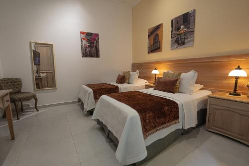 a hotel room with two beds and a desk at Hotel Casa La Fe in Cartagena de Indias
