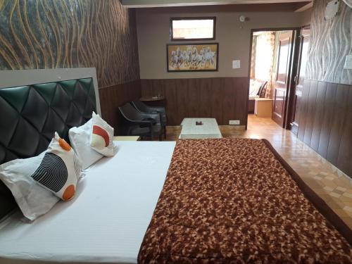 a hotel room with a large bed with two pillows at Anand Niketan Homestay Shimla in Shimla