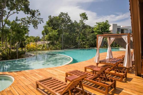 a deck with chairs and a swimming pool at Ophelia Experience in Tulum